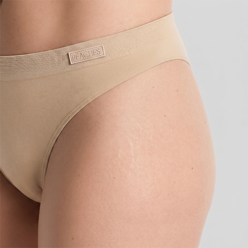 Peaches seamless Brazilian underwear on model — side close up view, The Confident Trio Pack